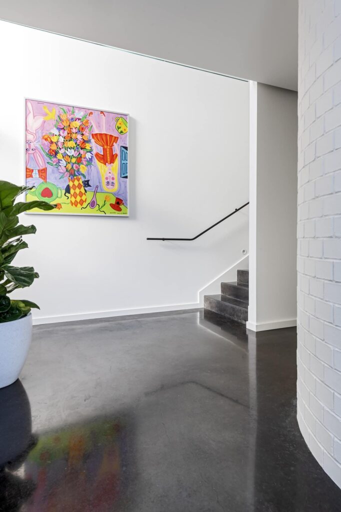 Hallway with polished black concrete floor and stairs