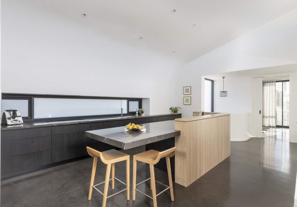 Kitchen area with granite counters on a polished black concrete floor